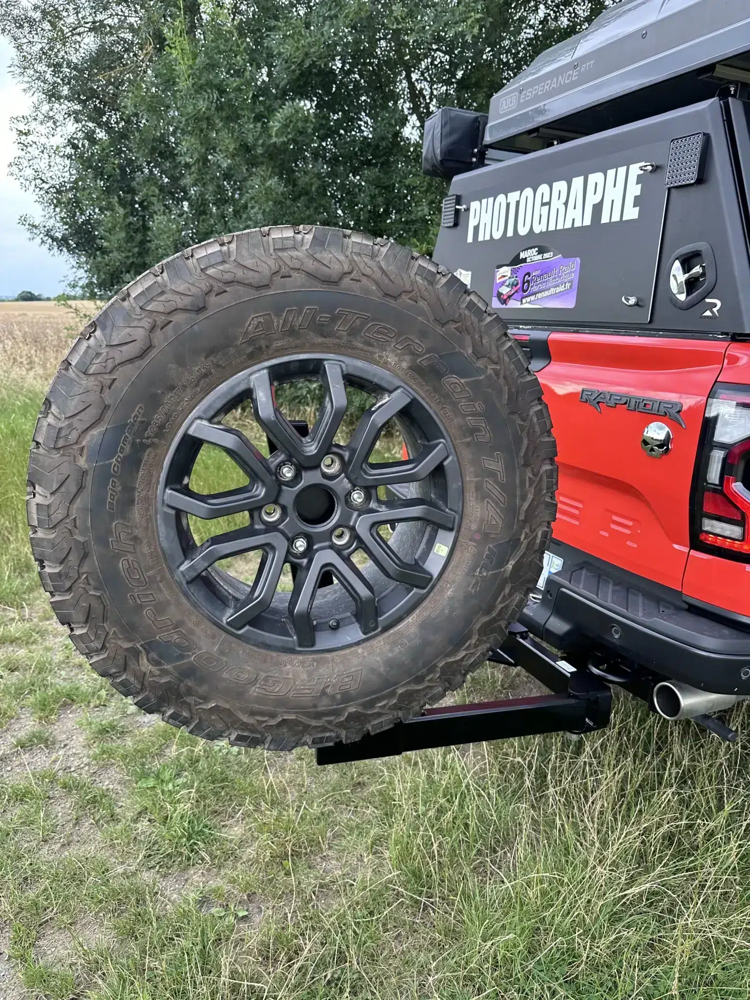 Roue de secours sur véhicule tout-terrain rouge.