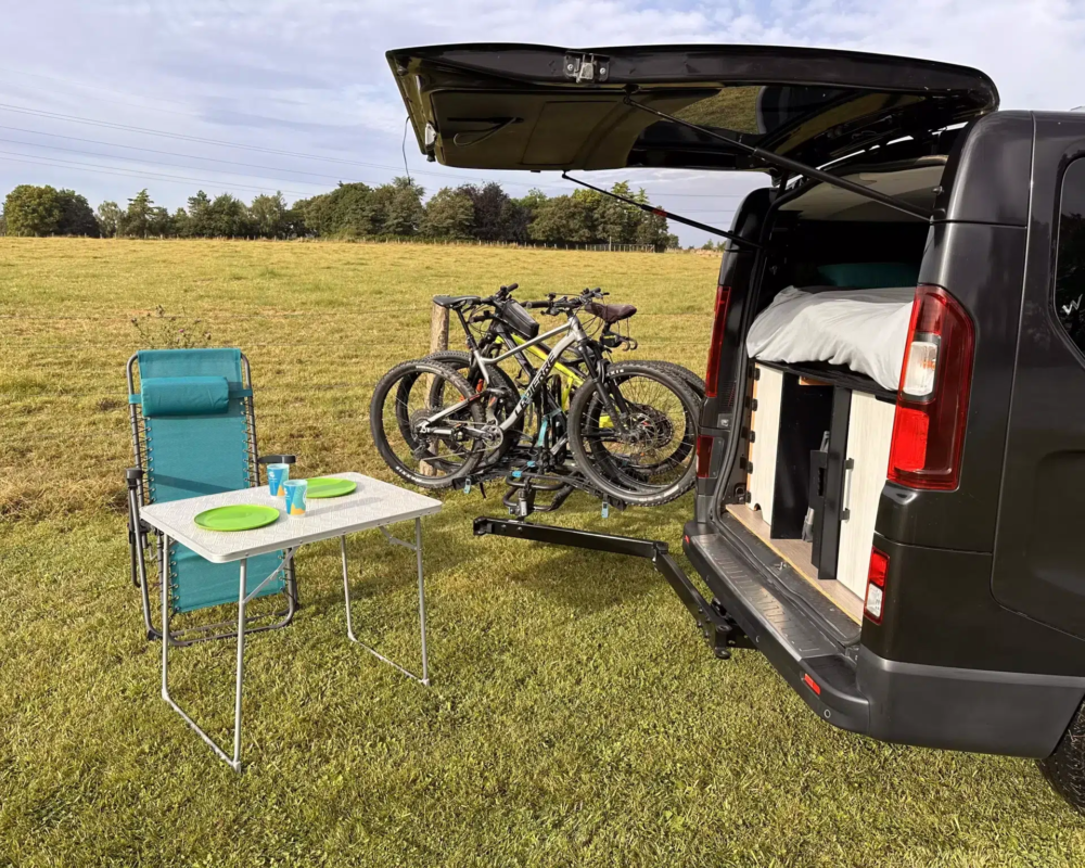 Camping-car avec vélos sur fond de nature.