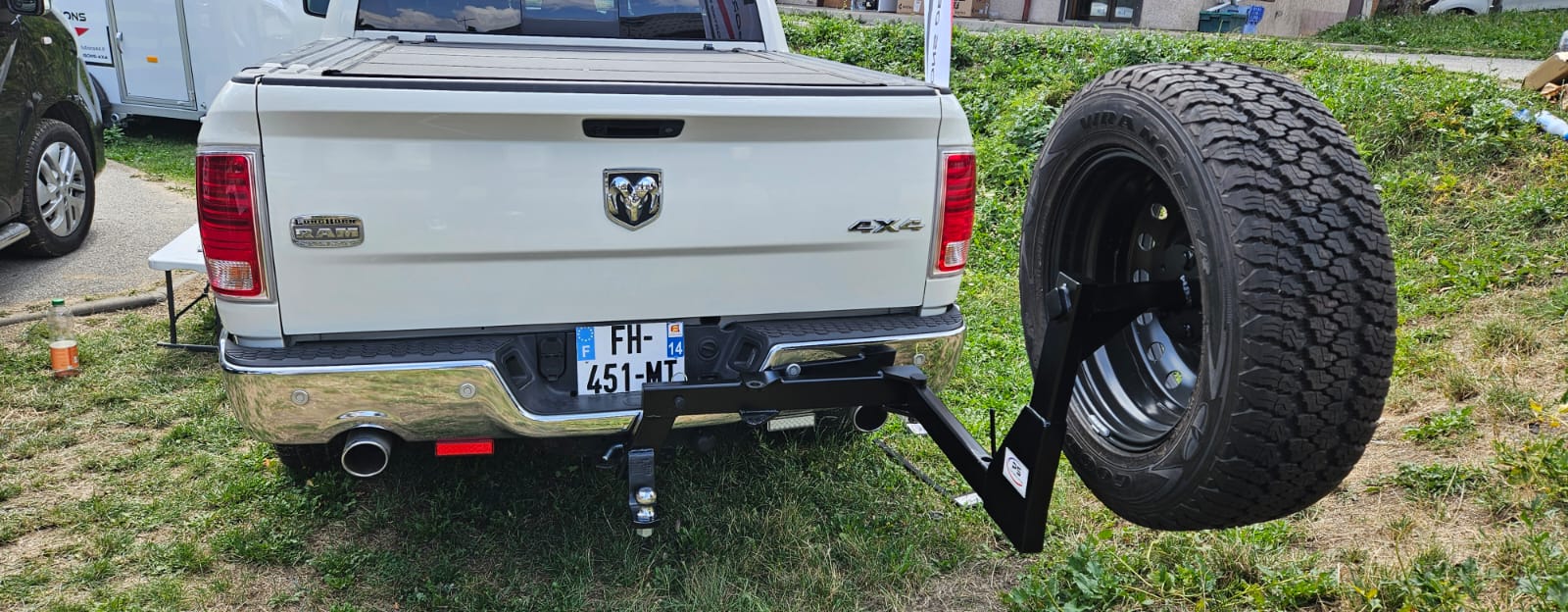 Pick-up blanc avec roue de secours externe.