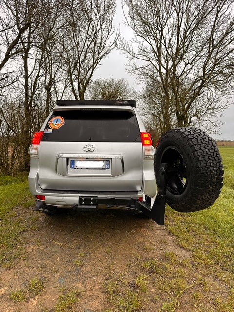 4x4 Toyota gris avec roue de secours arrière.