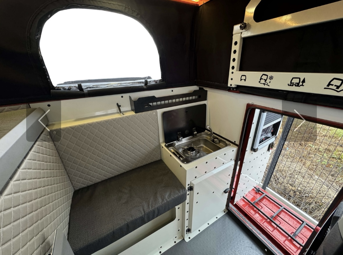 Screenshot Intérieur moderne de van aménagé avec cuisine.